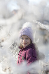 Portrait of happy girl wearing bobble hat in winter - SARF03097