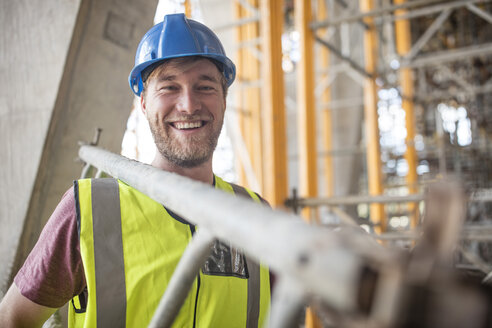 Construction worker on construction site carrying ladder - ZEF11887