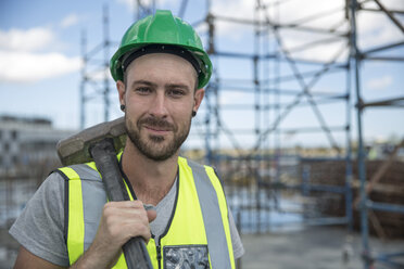 Construction worker on construction site holding sledge hammer - ZEF11901