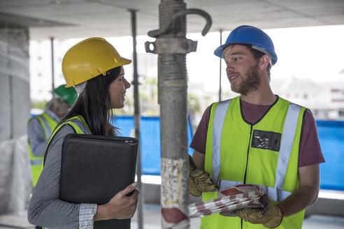 Engineer inspecting construction site, talking to workers - ZEF11902