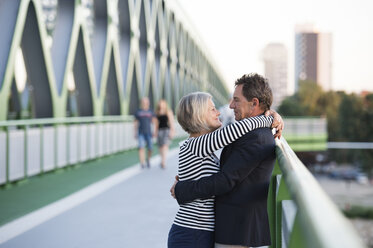 Älteres Paar umarmt sich auf einer Brücke - HAPF01250