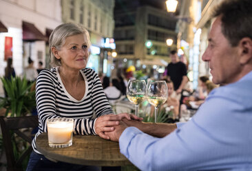 Senior couple drinking wine at an outdoor bar - HAPF01258