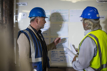Bauarbeiter und Ingenieur besprechen das Projekt im Baubüro - ZEF11925