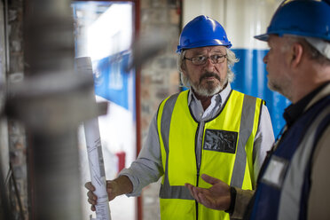 Bauarbeiter und Ingenieur besprechen das Projekt im Baubüro - ZEF11927