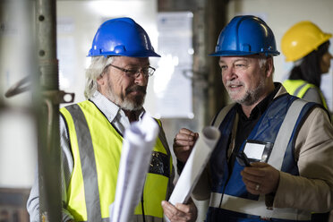 Bauarbeiter und Ingenieur besprechen das Projekt im Baubüro - ZEF11931