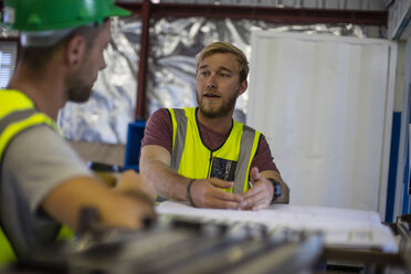 Bauarbeiter und Ingenieur besprechen das Projekt im Baubüro - ZEF11941