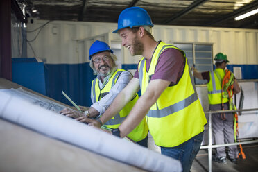 Construction worker and engineer discussing project in site office - ZEF11943