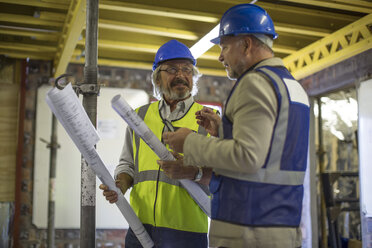 Construction worker and engineer discussing project in site office - ZEF11946