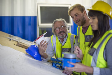 Bauarbeiter und Ingenieur besprechen das Projekt im Baubüro - ZEF11950