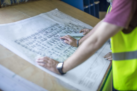 Engineers looking at blueprints in site office stock photo
