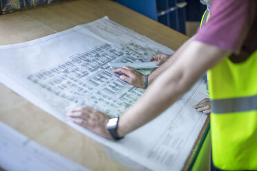 Engineers looking at blueprints in site office - ZEF11957