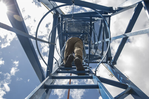 Arbeiter, der auf einen Baukran klettert, Blick von unten - ZEF11975