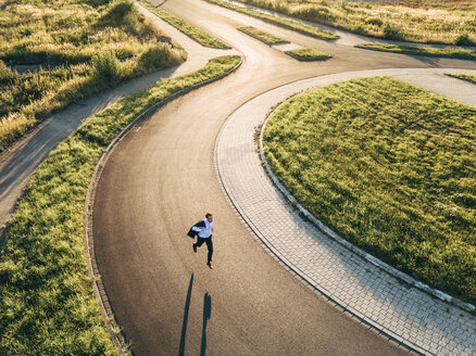 Businessman running in roundabout - KNSF00806