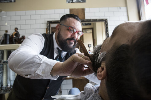 Barbier rasiert einen Mann mit einem Rasiermesser - ABZF01672