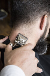 Barbier schneidet die Haare eines Mannes mit einer alten handbetriebenen Haarschneidemaschine - ABZF01676