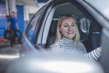 Lächelnde Kundin im Auto beim Verlassen der Werkstatt - ZEF11991