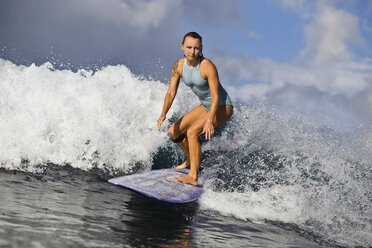 Indonesia, Bali, woman surfing on a wave stock photo