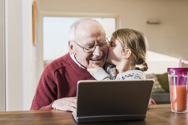 Großvater und Enkelin benutzen gemeinsam einen Laptop - UUF09540