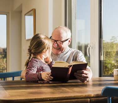 Großvater liest Geschichte für seine Enkelin vor - UUF09552