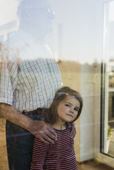 Großvater und Enkelin schauen aus dem Fenster - UUF09567