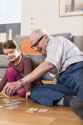 Grandfather and granddaughter playing memory - UUF09570