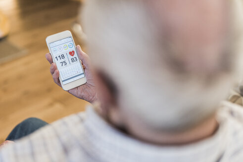 Ein älterer Mann benutzt eine Smartphone-App - UUF09575