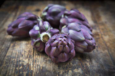 Purple organic artichokes on dark wood - LVF05739