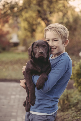 Boy holding Labrador Retriever stock photo