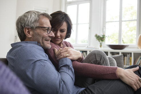 Smiling mature couple at home on the sofa - RBF05392