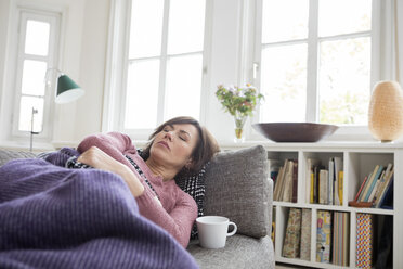 Woman with stomach ache lying on the sofa - RBF05397