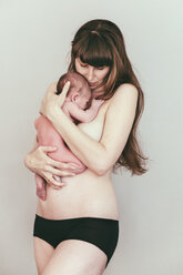 Semi-nude mother holding her newborn baby - MFF03402