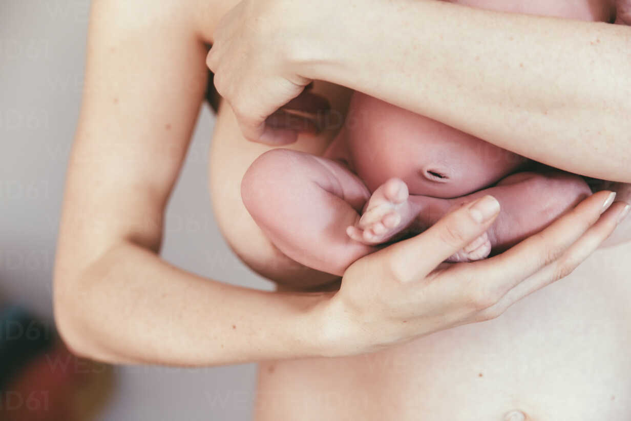 Close-up of nude mother holding her newborn baby stock photo