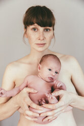 Porträt einer nackten Mutter, die ihr neugeborenes Baby hält - MFF03407