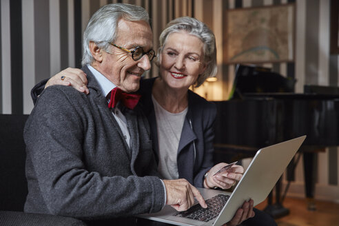 Glückliches Seniorenpaar beim Online-Einkauf zu Hause - RHF01685