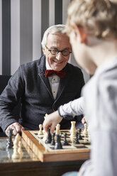 Großvater und Enkel spielen Schach - RHF01721