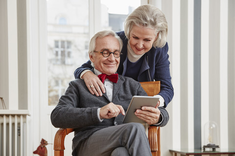 Lächelndes älteres Ehepaar mit Tablet, lizenzfreies Stockfoto