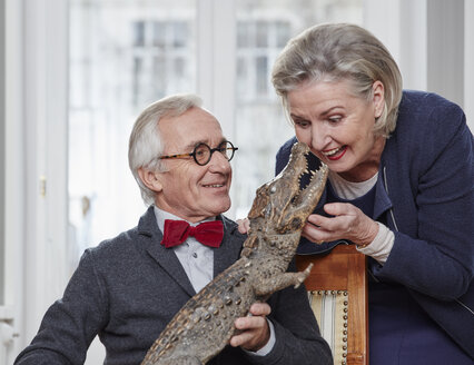 Verspieltes Seniorenpaar mit taxidermisiertem Krokodil - RHF01759
