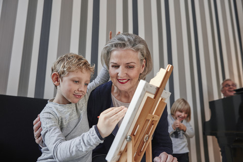 Grandmother and grandson with Dali moustache at easel stock photo