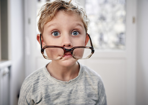 Portrait of playful boy with oversized glasses stock photo