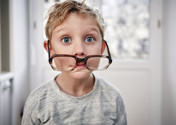 Porträt eines verspielten Jungen mit übergroßer Brille - RHF01768