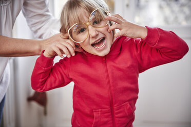 Portrait of playful girl wearing oversized glasses - RHF01770