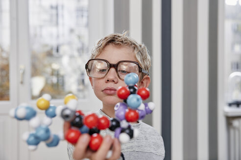 Boy wearing oversized glasses looking at molecular model - RHF01772