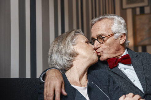 Älteres Paar küsst sich auf der Couch - RHF01777