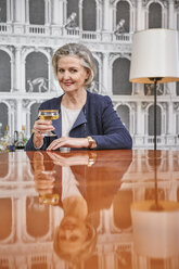 Porträt einer älteren Frau, die ein Glas Champagner trinkt - RHF01784