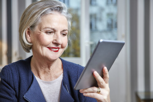 Lächelnde ältere Frau mit Tablet - RHF01795