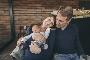 Mother and father with newborn baby sitting in cafe - MFF03409