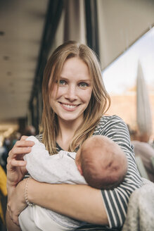 Porträt einer lächelnden Mutter mit Baby in einem Café - MFF03410