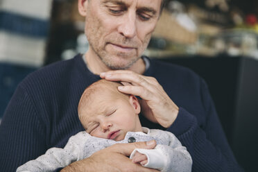 Reifer Vater berührt den Kopf seines schlafenden Babys - MFF03416