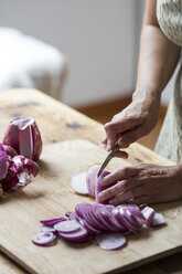 Woman preparing red onions for onion pesto - ALBF00053