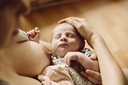 Schläfriges Neugeborenes nach dem Trinken an der Brust der Mutter - MFF03417